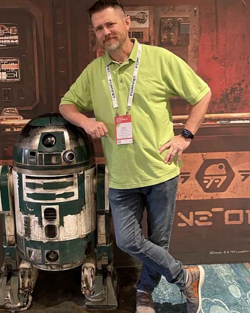 Nick Sanders standing next to an R2 unit at Disney's Hollywood Studios Galaxy's Edge.